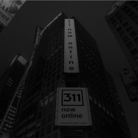 Photo of a billboard on a building that reads '311 now online'